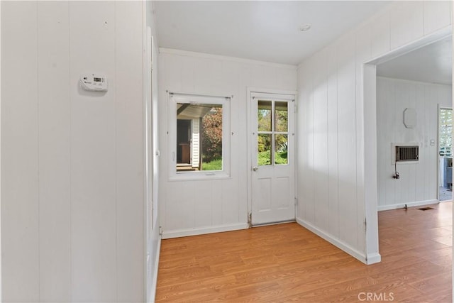 doorway to outside with wood walls and light wood-type flooring