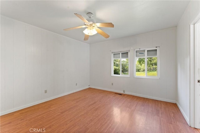 empty room with light hardwood / wood-style flooring and ceiling fan