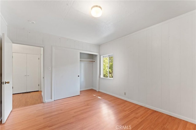 unfurnished bedroom featuring light hardwood / wood-style floors and a closet