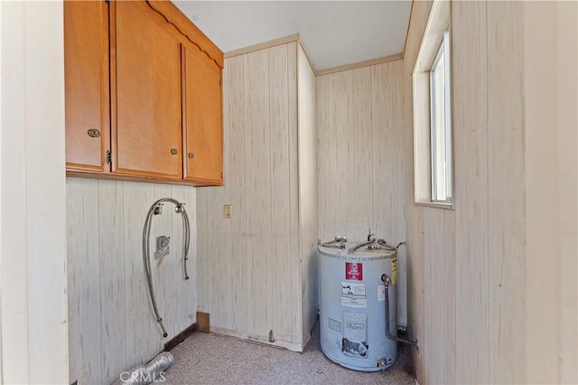 laundry area with cabinets, electric water heater, and wooden walls