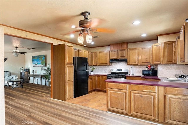 kitchen with black appliances, sink, decorative backsplash, light hardwood / wood-style floors, and kitchen peninsula