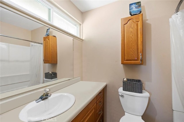 bathroom featuring vanity, toilet, and curtained shower