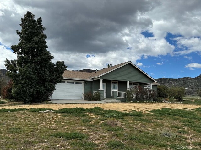 view of front of property with a garage, a front yard, and a porch