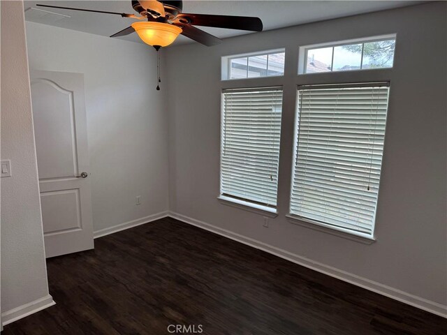 empty room featuring dark wood-type flooring and ceiling fan