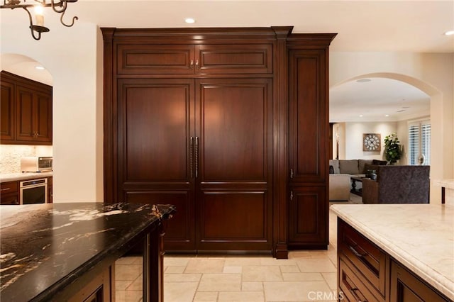 kitchen featuring dark stone countertops and tasteful backsplash