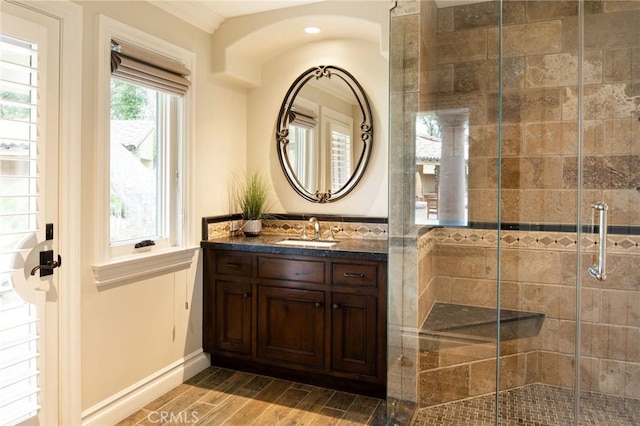 bathroom with a shower with door, vanity, and hardwood / wood-style flooring