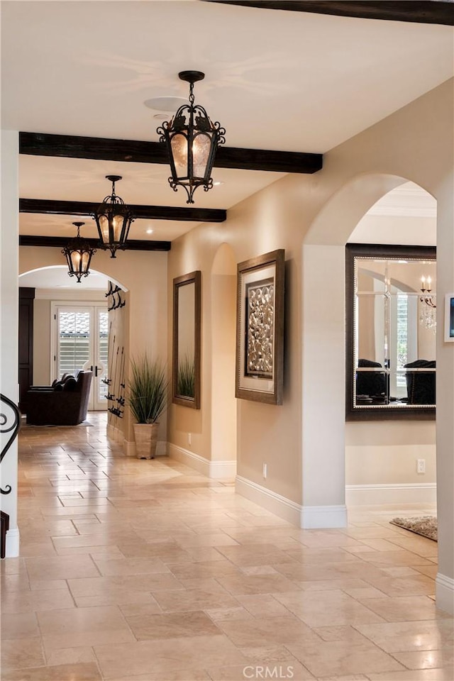 interior space featuring a wealth of natural light, french doors, and beamed ceiling