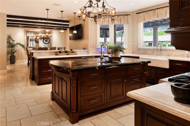 kitchen with a center island, sink, dark brown cabinetry, and hanging light fixtures