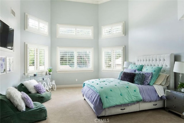 bedroom featuring a high ceiling, carpet floors, and multiple windows