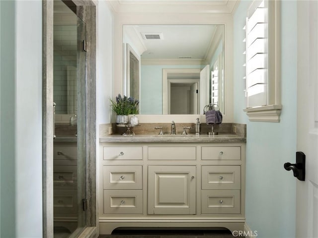 bathroom featuring crown molding, vanity, and a shower with shower door