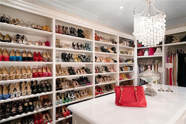 spacious closet featuring an inviting chandelier