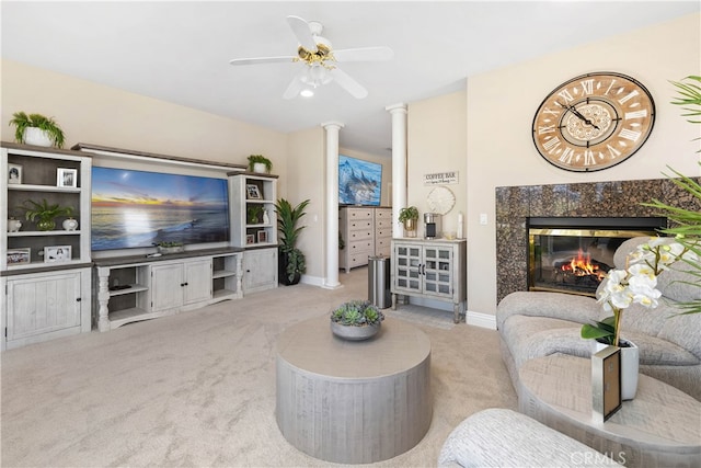 living room with a high end fireplace, light carpet, and ceiling fan