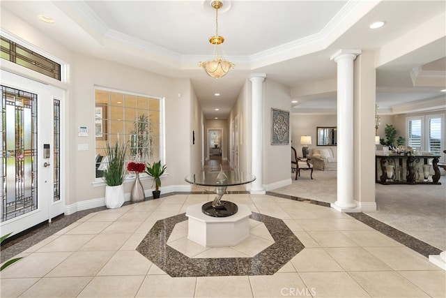 entryway featuring light carpet, a tray ceiling, crown molding, and ornate columns