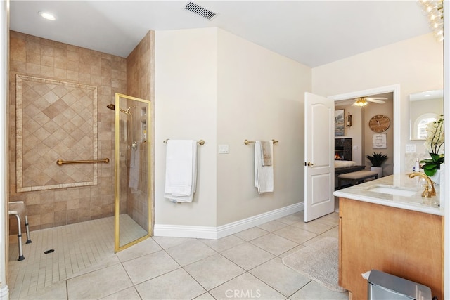 bathroom with a tile shower, tile patterned flooring, ceiling fan, and vanity