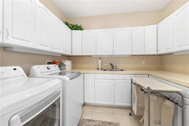 washroom featuring cabinets, sink, washer and dryer, and light tile patterned flooring