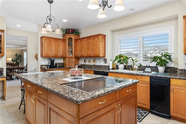 kitchen with black appliances, a kitchen island, pendant lighting, and a notable chandelier