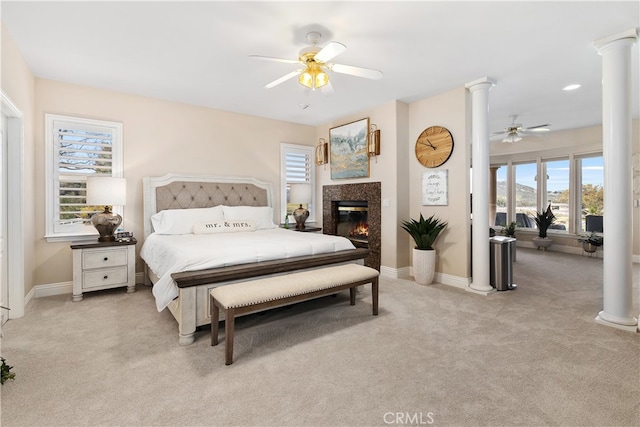 bedroom with decorative columns, ceiling fan, and light colored carpet