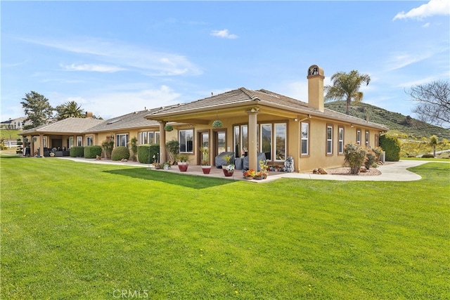 rear view of house with a yard and a patio area