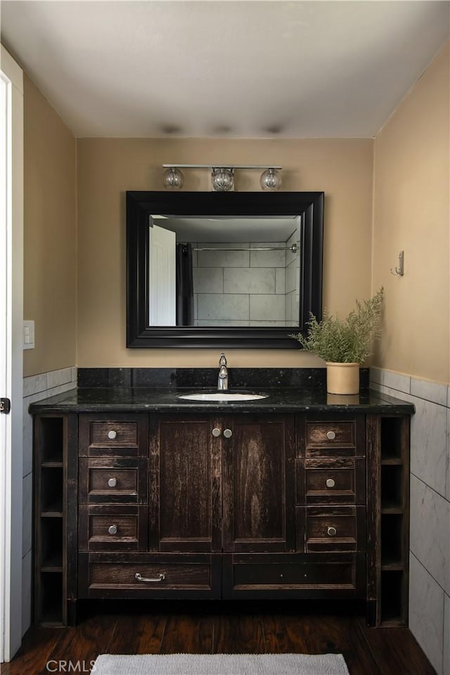 bathroom with hardwood / wood-style floors, vanity, and tile walls