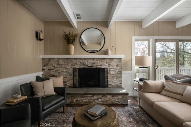 living room with beam ceiling, wooden ceiling, dark hardwood / wood-style flooring, wood walls, and a fireplace