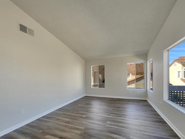 unfurnished room with dark hardwood / wood-style floors and a textured ceiling