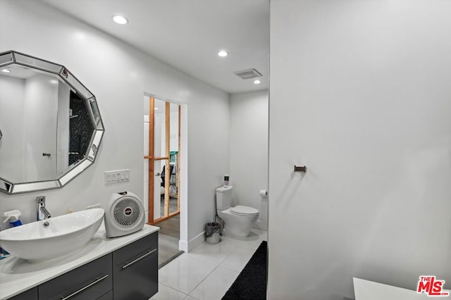 bathroom featuring vanity, tile floors, and toilet