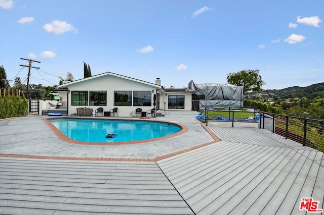 view of swimming pool with a wooden deck and a patio area