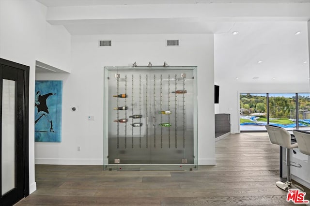 interior space with beam ceiling and dark wood-type flooring