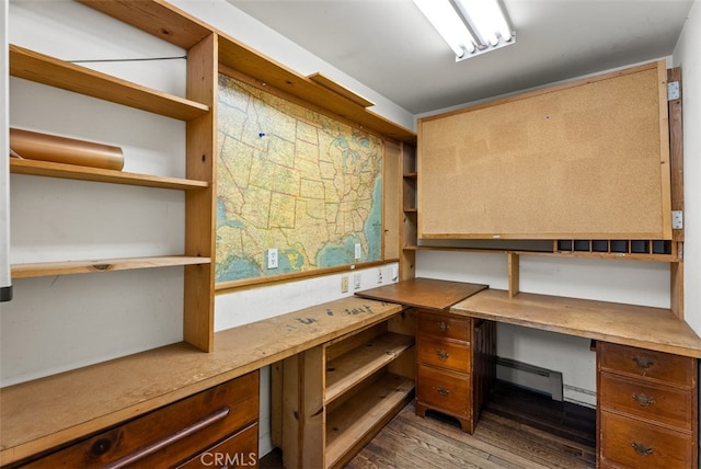 office featuring a baseboard heating unit, built in desk, and hardwood / wood-style flooring