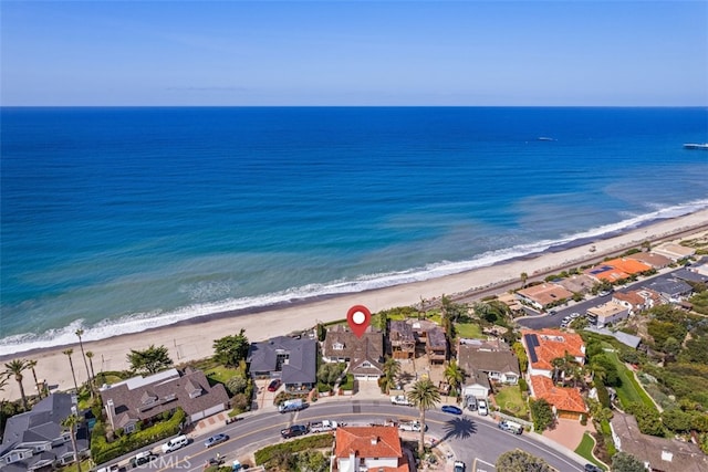 drone / aerial view featuring a beach view and a water view