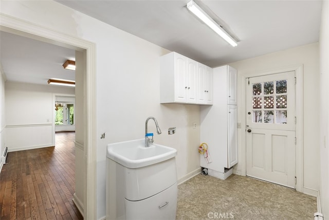 laundry area featuring cabinets and hardwood / wood-style flooring