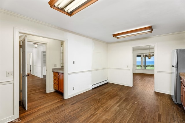 empty room featuring a baseboard heating unit, dark hardwood / wood-style floors, and a notable chandelier