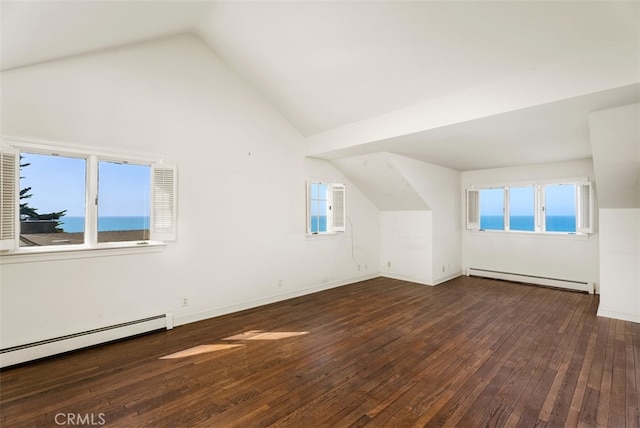 additional living space featuring lofted ceiling, a baseboard radiator, a wealth of natural light, and dark hardwood / wood-style flooring