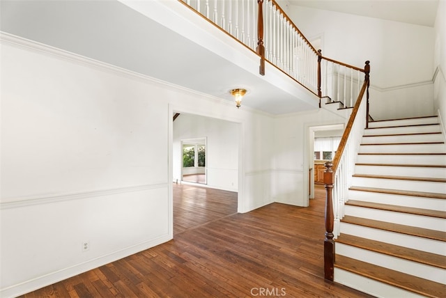 stairway featuring crown molding and hardwood / wood-style floors