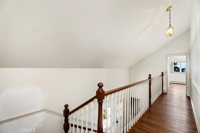 hall with baseboard heating, dark hardwood / wood-style floors, and vaulted ceiling