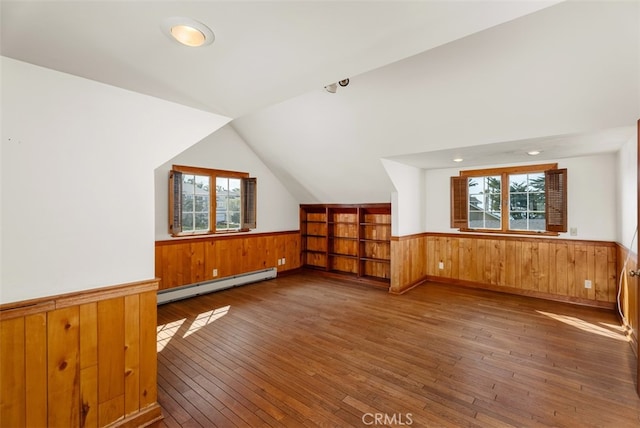 bonus room with lofted ceiling, a baseboard heating unit, and hardwood / wood-style floors