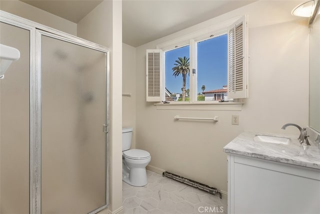 bathroom featuring vanity, toilet, a shower with shower door, and tile patterned floors