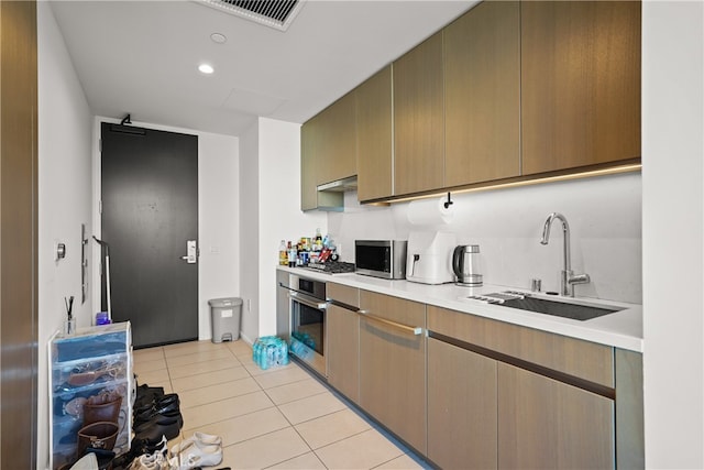 kitchen featuring appliances with stainless steel finishes, sink, and light tile patterned floors