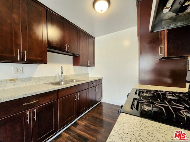 kitchen with black range oven, light stone countertops, dark hardwood / wood-style flooring, dark brown cabinets, and sink