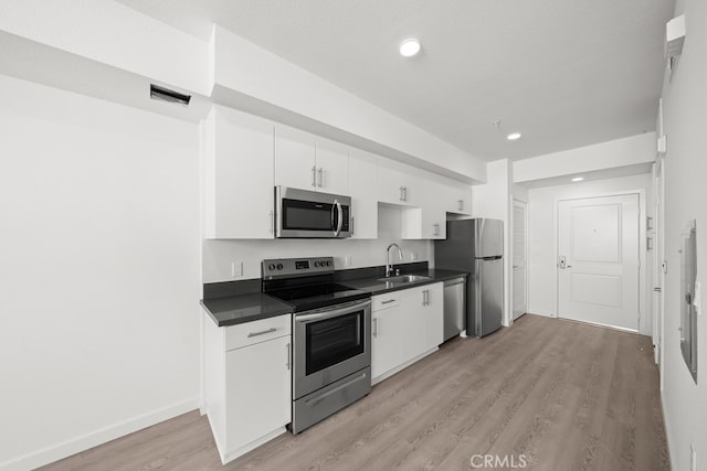 kitchen featuring light hardwood / wood-style flooring, appliances with stainless steel finishes, sink, and white cabinetry