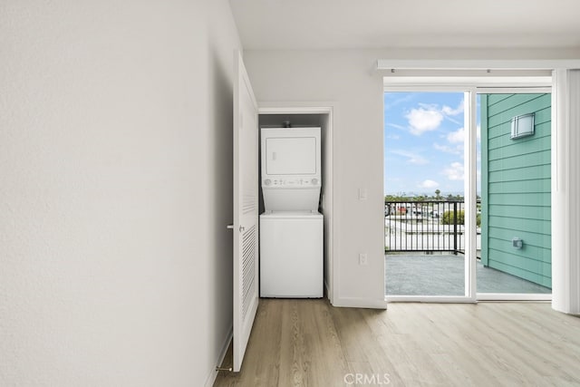 interior space featuring stacked washing maching and dryer and light hardwood / wood-style floors