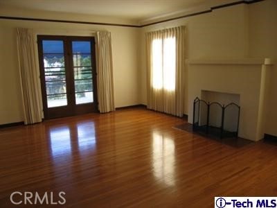 empty room featuring hardwood / wood-style flooring and french doors