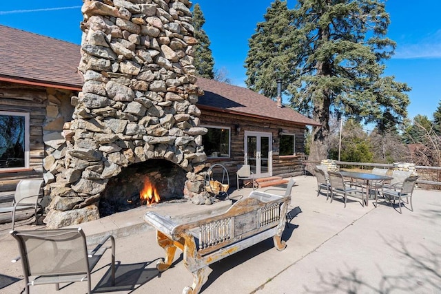 view of patio / terrace with french doors and an outdoor stone fireplace