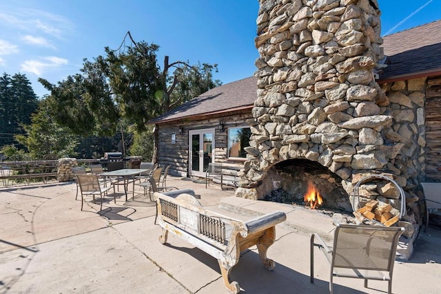 view of terrace with an outdoor stone fireplace