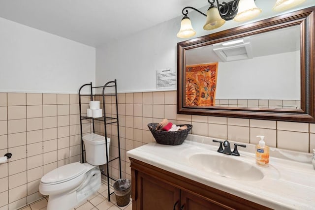 bathroom with toilet, tile walls, tile flooring, and vanity