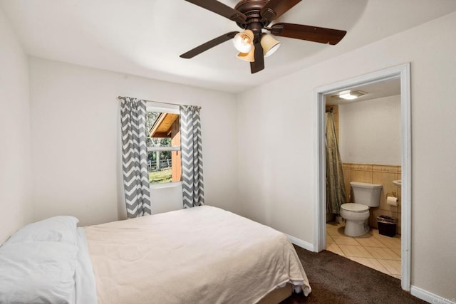 tiled bedroom featuring ceiling fan and connected bathroom