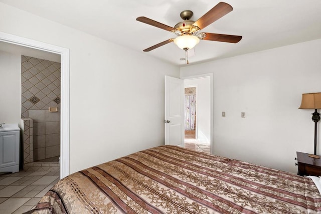 bedroom with light tile floors, ceiling fan, and ensuite bathroom