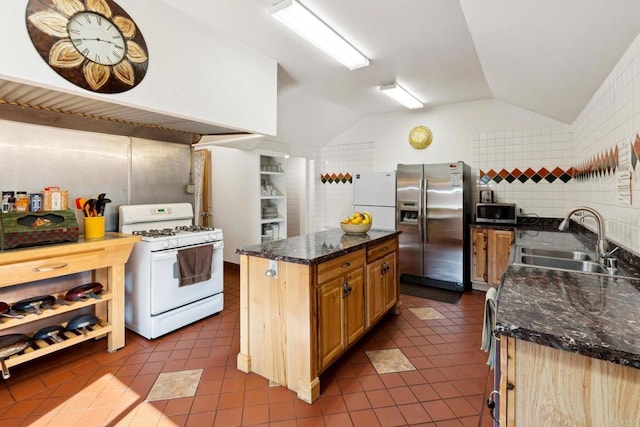 kitchen featuring sink, a center island, stainless steel appliances, light tile flooring, and lofted ceiling