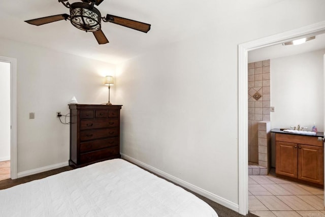 bedroom with ceiling fan, connected bathroom, sink, and light tile floors