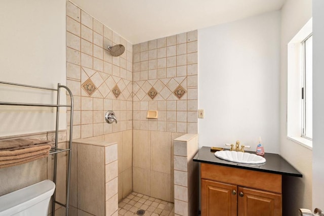 bathroom featuring vanity, toilet, and tiled shower